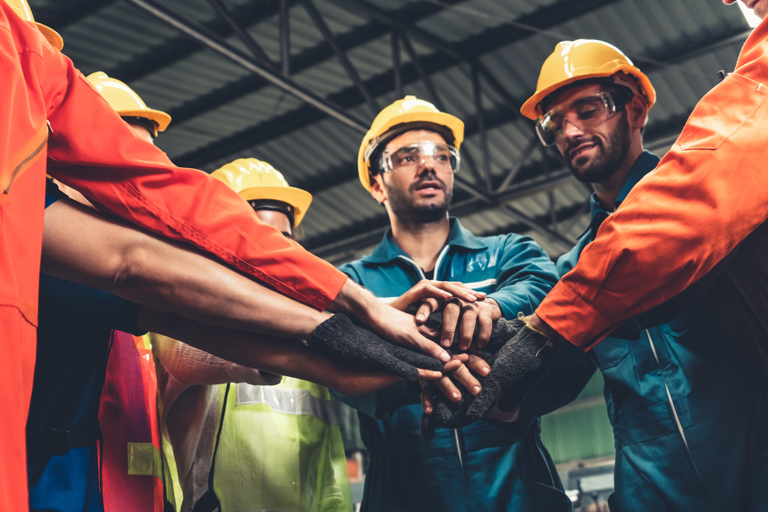 Skillful worker stand together showing teamwork in the factory . Industrial people and manufacturing labor concept .